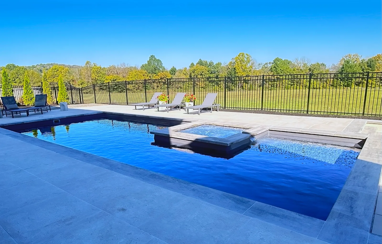 Fiberglass pool with paver decking and lounge seating